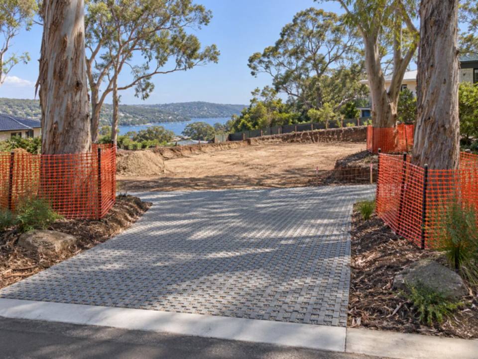 Representative image of retained trees with protection fencing beside a permeable paved driveway